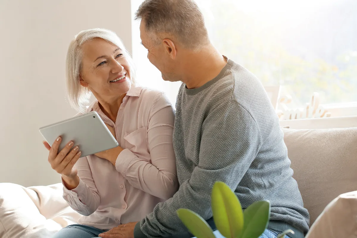 An older couple looking at a tablet together at home